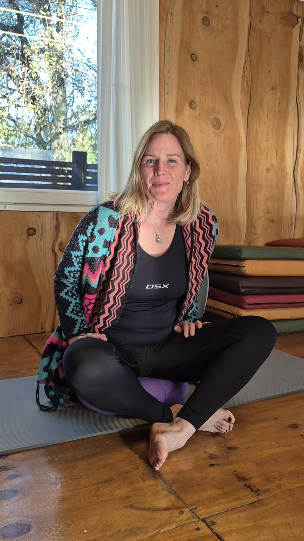 Alexandra Otto sentada sobre su mat de yoga